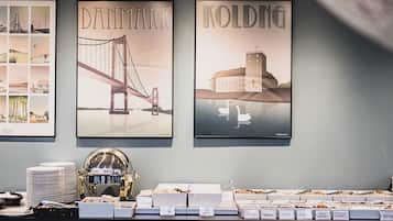 Three framed posters of bridges and a buffet area with labeled food containers.