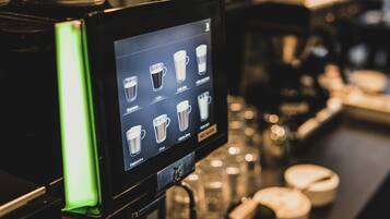 Pantalla digital de menú en una máquina de café que muestra varias opciones de bebidas.