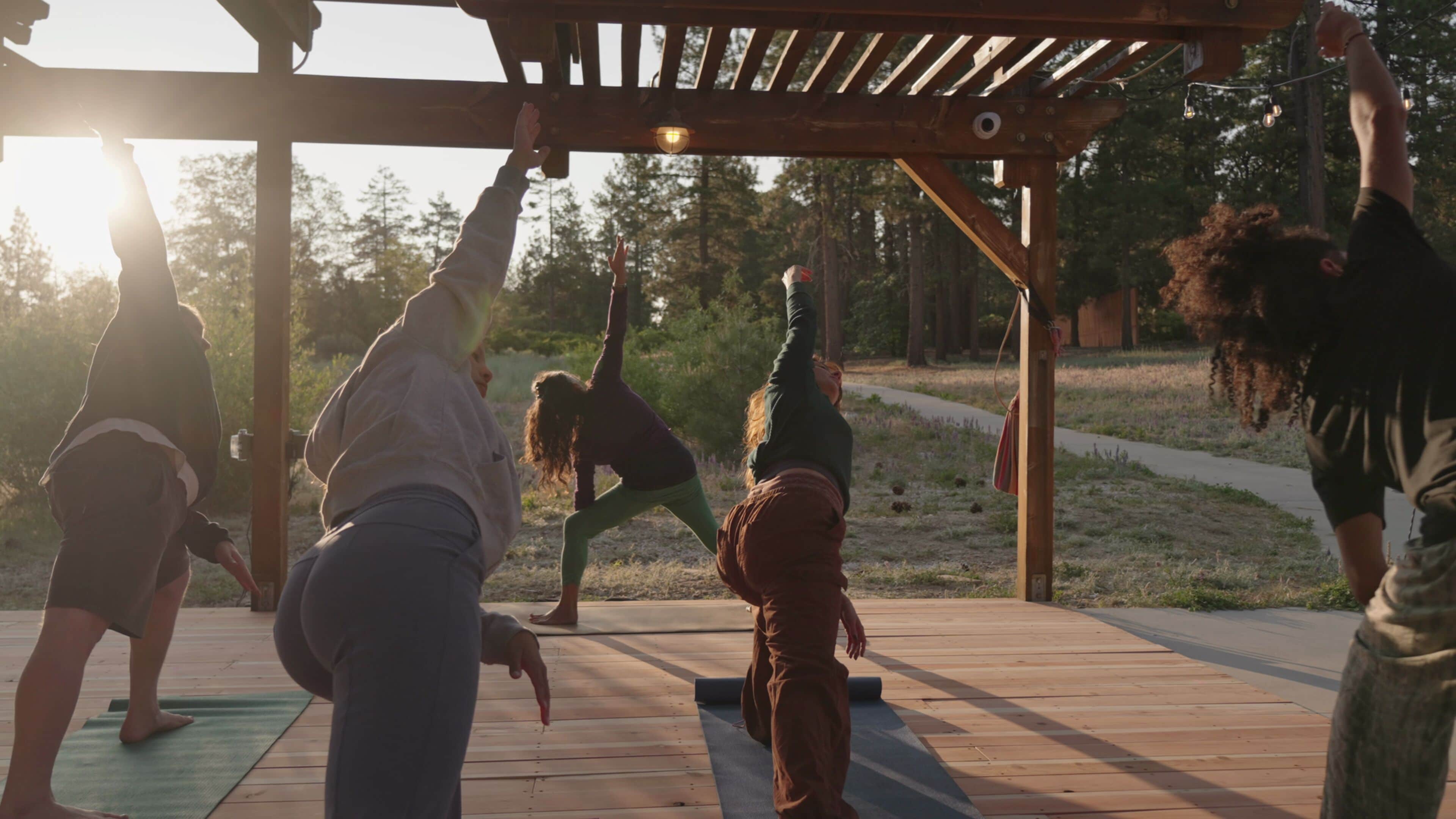 A wooden deck with people practicing yoga.