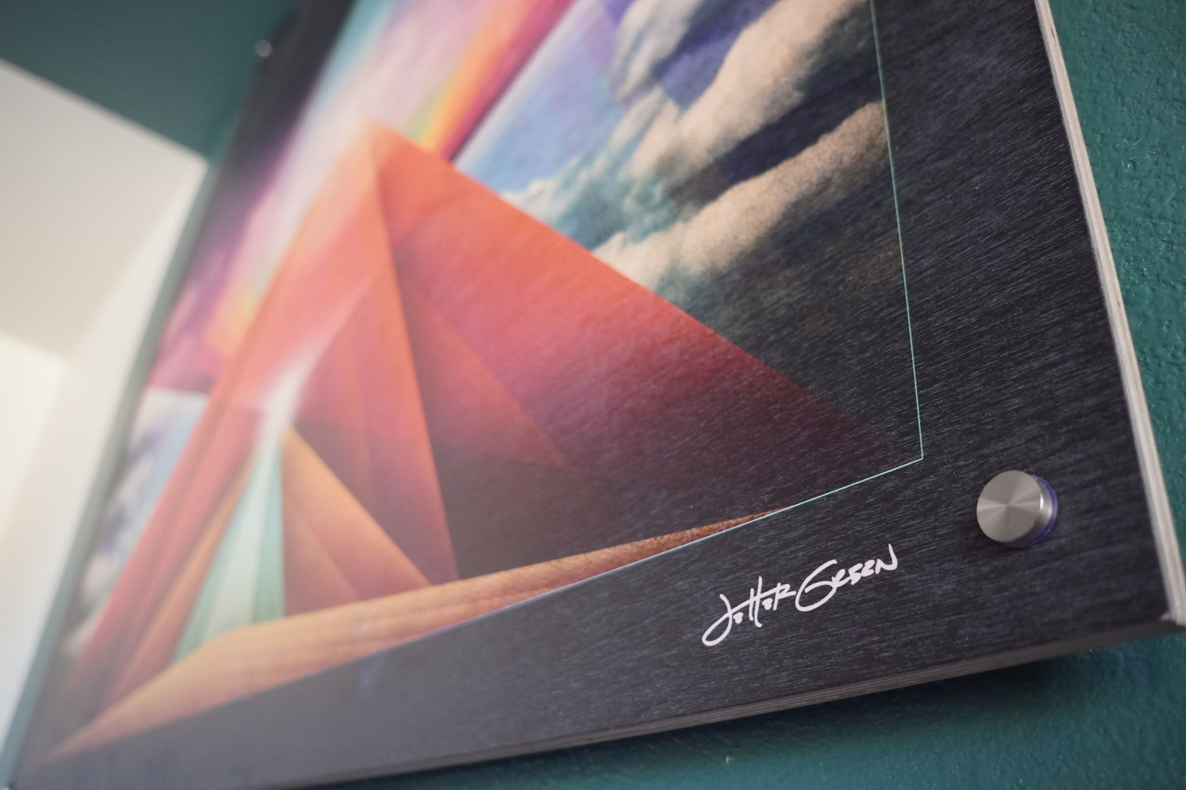 A framed artwork with a signature on the lower right.
