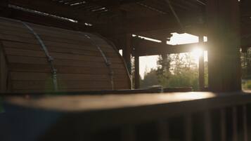 A wooden barrel structure with metal straps, likely part of a rustic building or outdoor seating area.