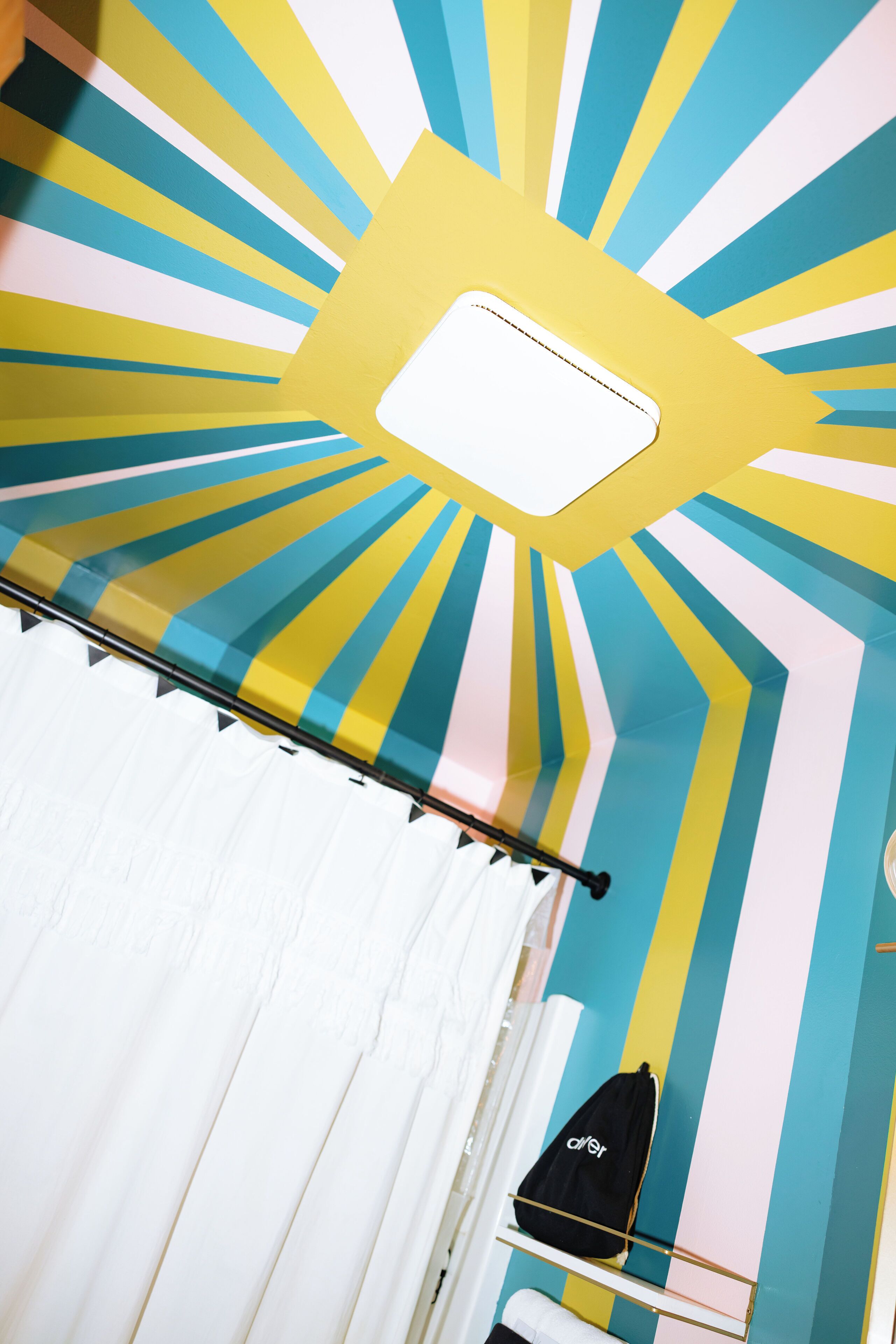 Una stanza con un soffitto decorato con un motivo a raggiera e un condizionatore d'aria bianco.