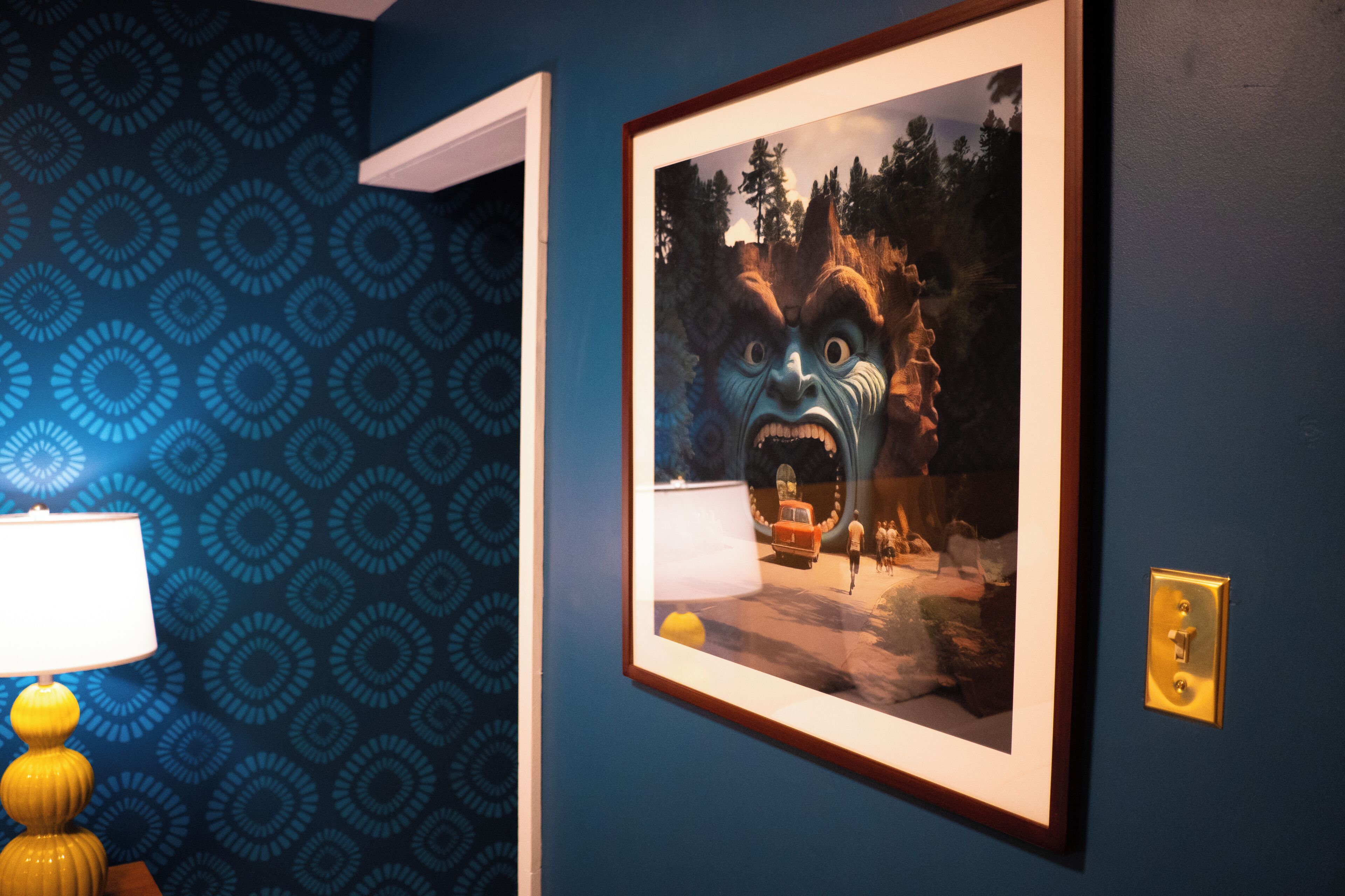 A framed picture on a wall with a patterned wallpaper background.