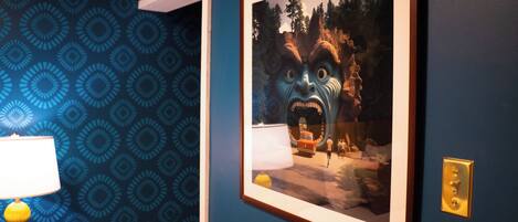 A framed picture on a wall with a patterned wallpaper background.