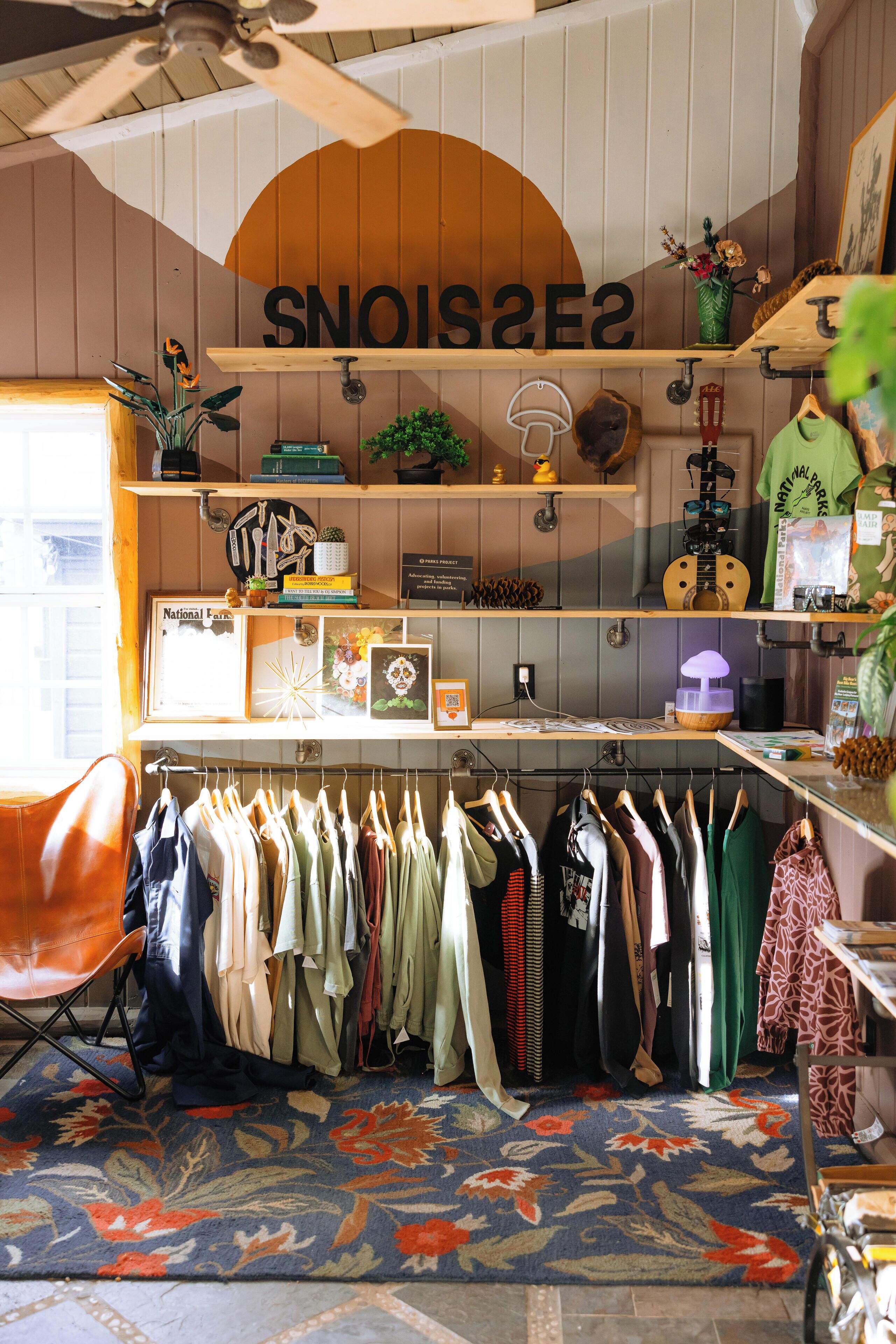 A room with a clothing rack, shelves with various items, and a sign with letters.