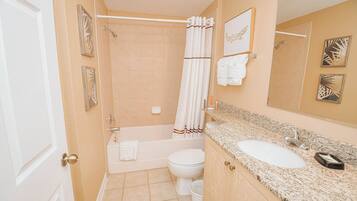 A bathroom with a bathtub, toilet, and sink.