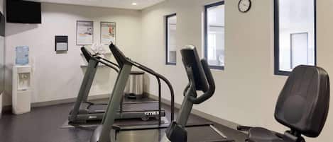 A gym with treadmills, a stationary bike, and a rowing machine.