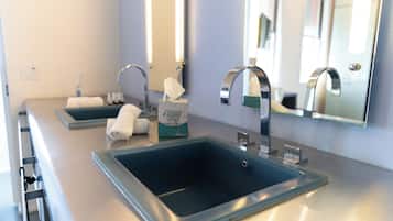 Ein modernes Badezimmer mit zwei Waschbecken, einem Spiegel und einem Handtuchhalter.