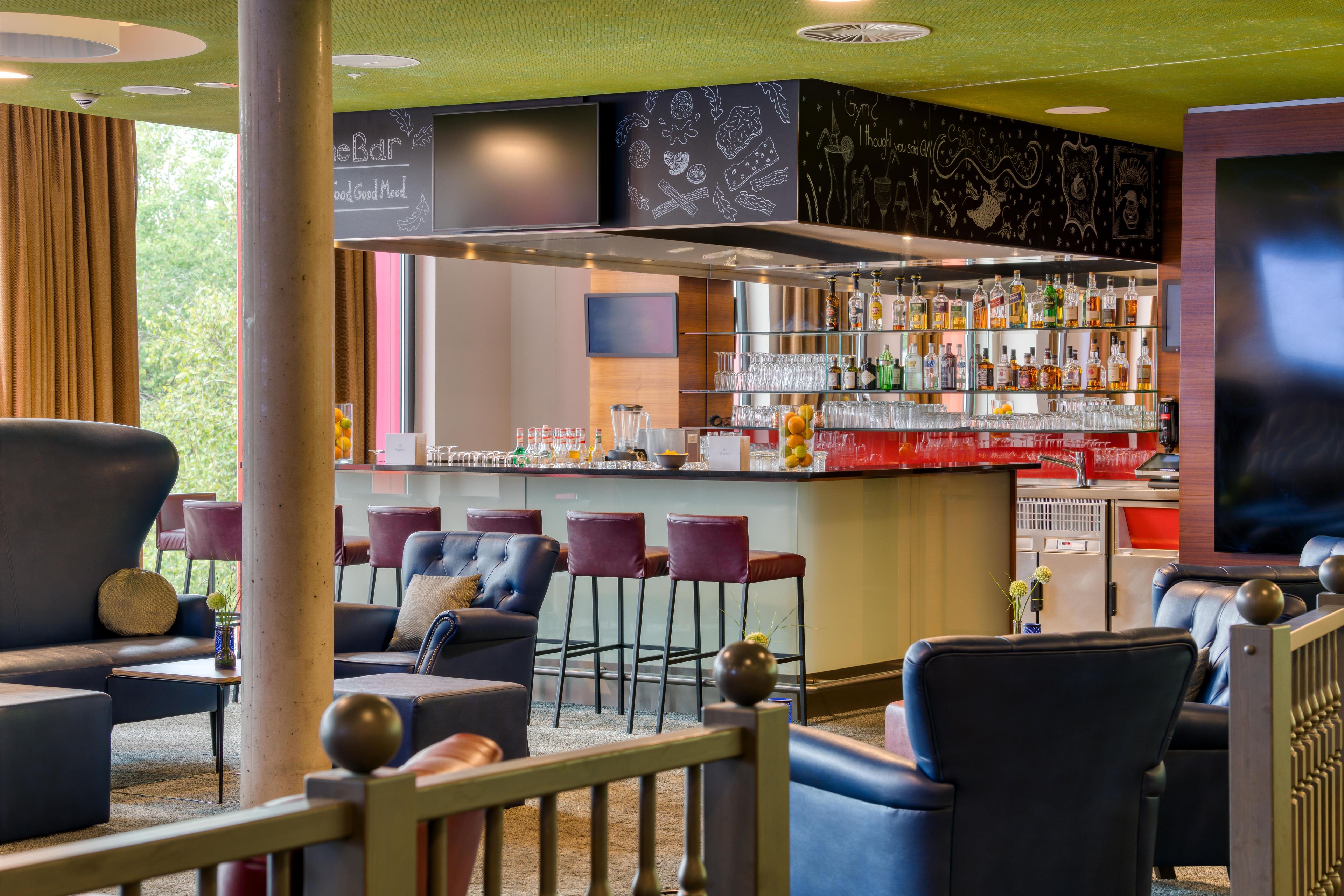 A bar area with seating and a television screen.