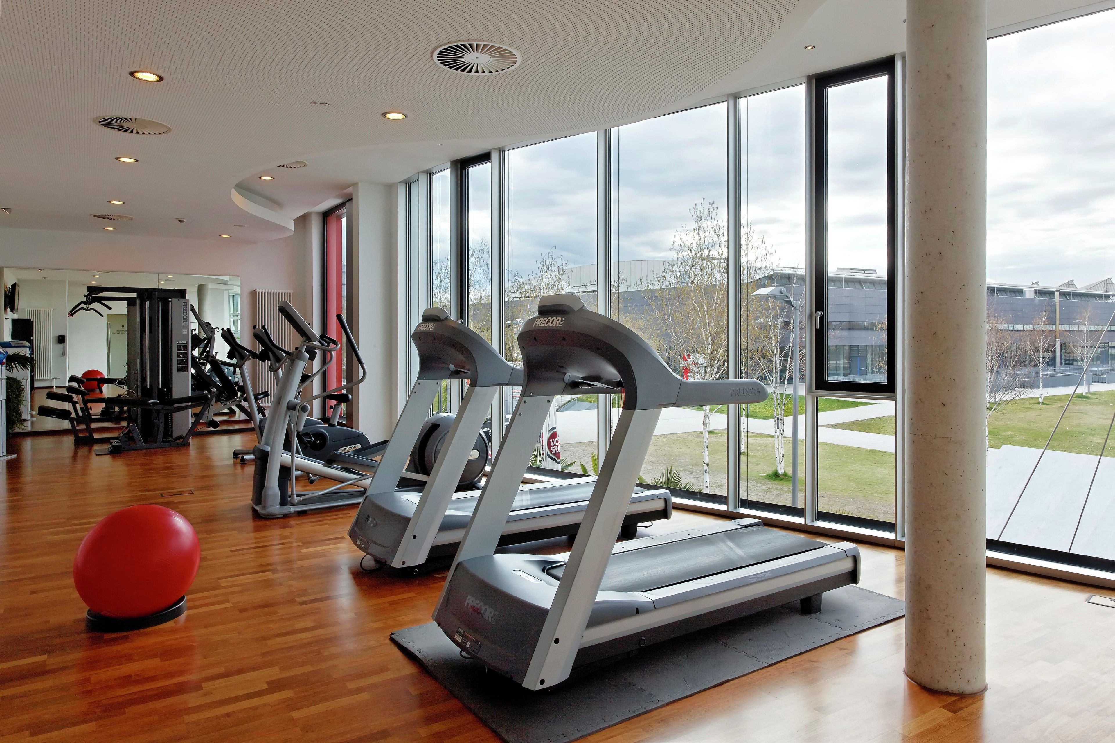 A gym with treadmills, exercise balls, and various fitness equipment.
