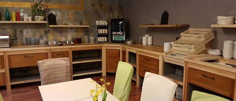 A cozy kitchen with wooden cabinets, a coffee machine, and a clock on the wall.
