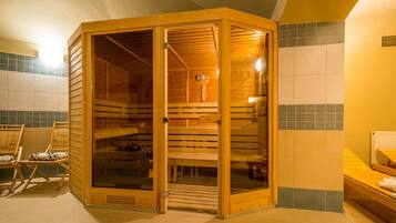 A sauna with a wooden exterior, glass doors, and a bench inside.