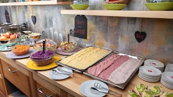 A buffet with various food items including ham, cheese, and sliced bread.