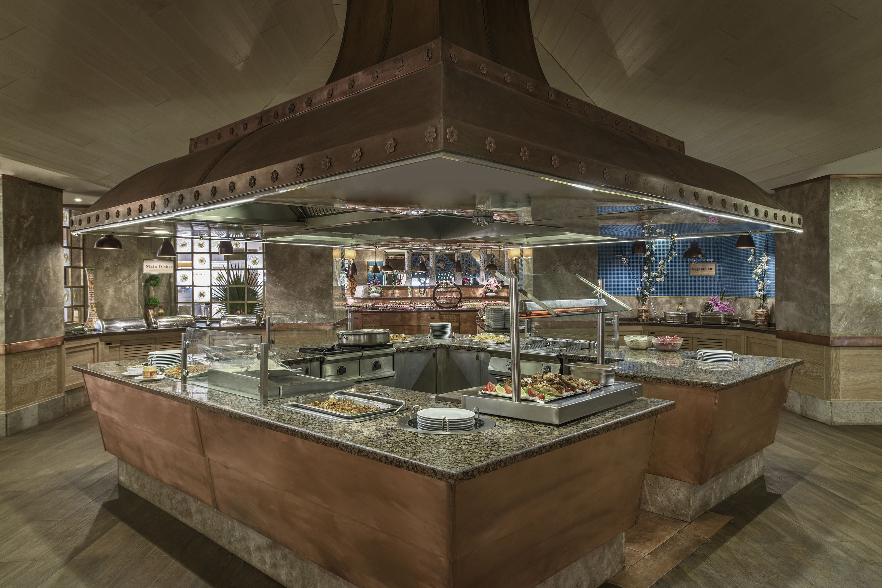 A buffet setup with multiple serving stations, a central island, and a decorative ceiling.