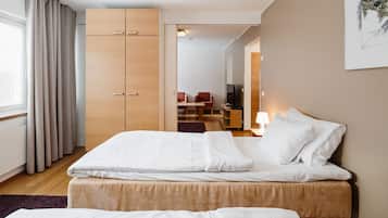 A hotel room with a bed, a wardrobe, a desk, and a chair.