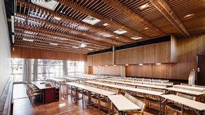 A conference room with long tables and chairs, wooden ceiling with slats, and large windows. - Hotel Rantapuisto (Helsinki)