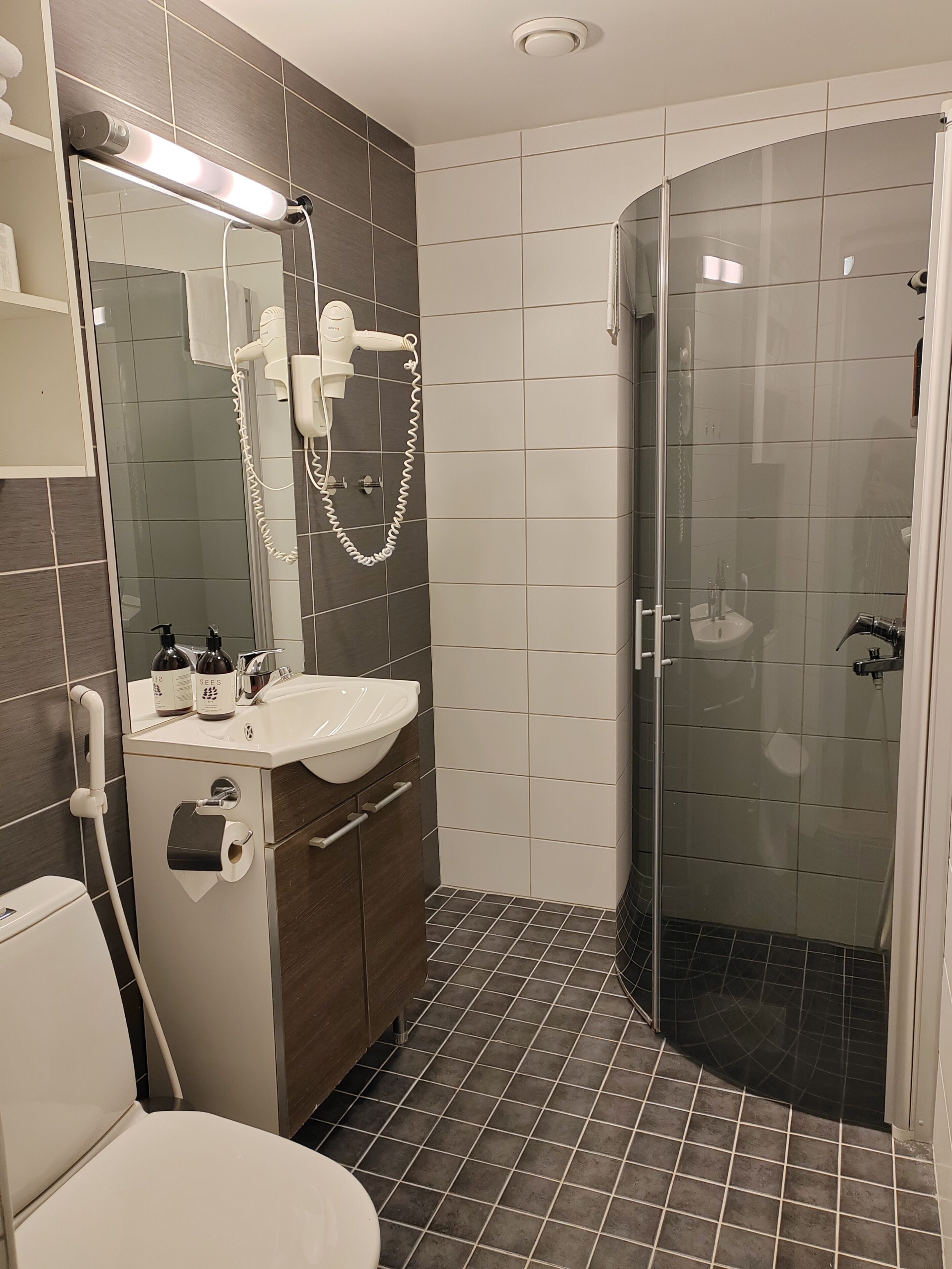 Uma casa de banho moderna com sanita, lavatório e cabine de duche em vidro.