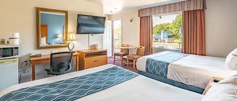 A hotel room with two beds, a desk with a chair, a television, and a window with curtains.