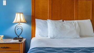 A hotel room with a bed, a nightstand with a lamp, and a telephone.