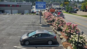 A parking lot with a car, a Huntsville Inn sign, and a building labeled "Muskoka Auto Parts". - Huntsville Inn (Huntsville)