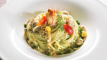 Un plato de pasta con verduras y hierbas aromáticas.