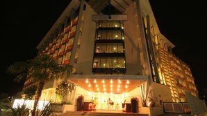 A modern hotel with a prominent entrance, multiple floors, and a well-lit facade.