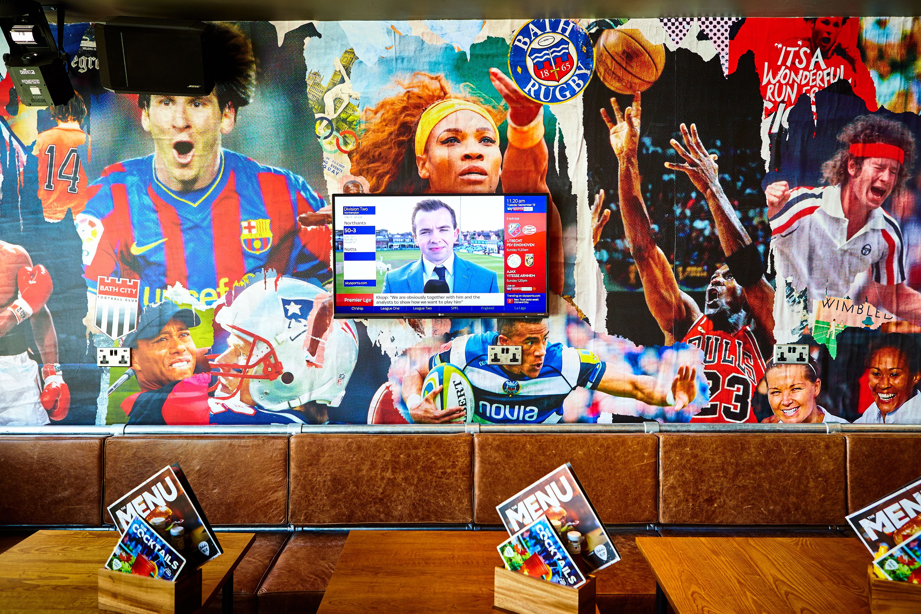 A sports-themed wall with various athletes and team logos.