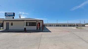 Un motel con un letrero que dice "AMERICAS BEST VALUE INN" y un anuncio de Coca-Cola en la fachada.