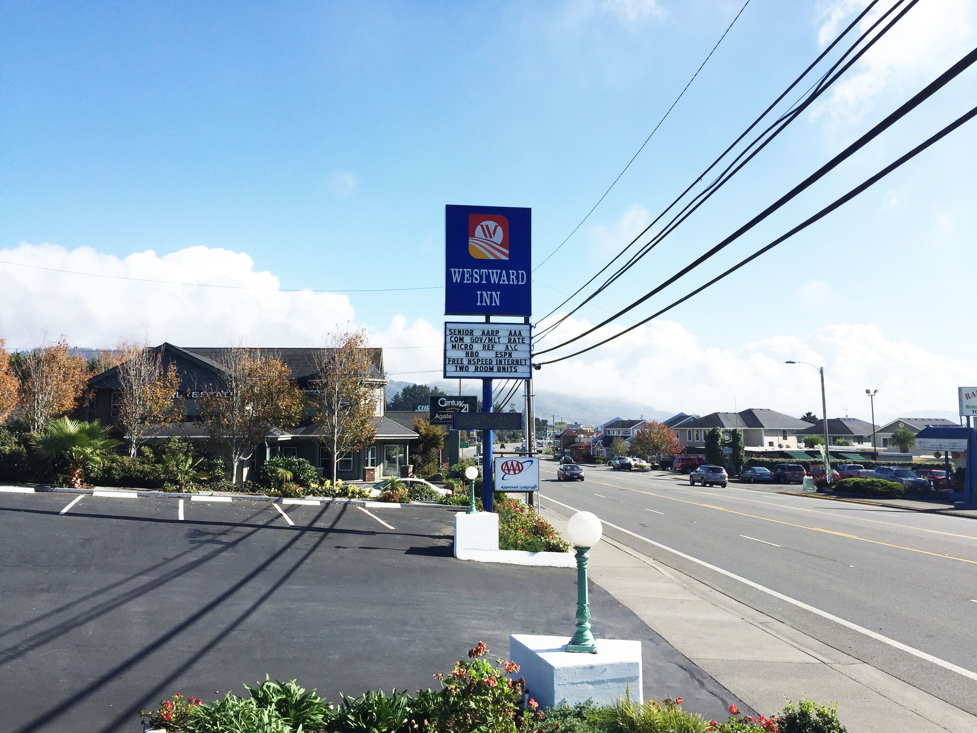 Zona comercial con un letrero que indica 'WESTWARD IN' y el hotel 'Agate 21'.
