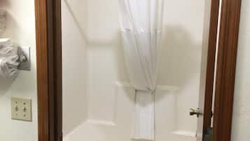 A bathroom with a bathtub, toilet, and a shower curtain.