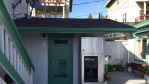 A building with a green door labeled "Storage Room C" and an ICE DISPENSE unit outside. - Westward Inn (Brookings)