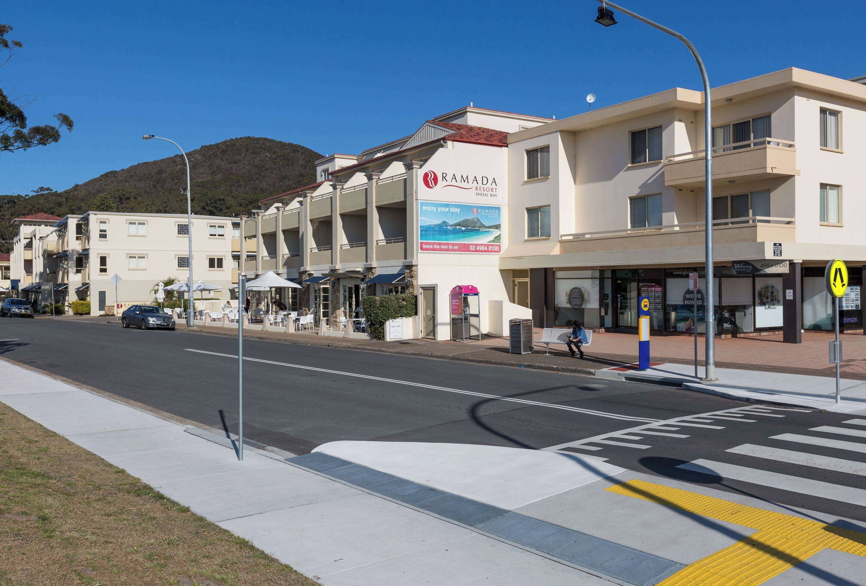 A hotel with a signboard advertising 'RAMADA RESORT' and 'enjoy your stay'.