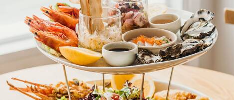 Un plato de mariscos con diversas preparaciones y bebidas sobre una mesa.