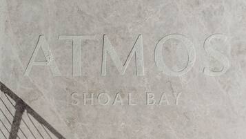 Eine strukturierte Steinwand mit dem erhabenen Text „ATMOS SHOAL BAY“.