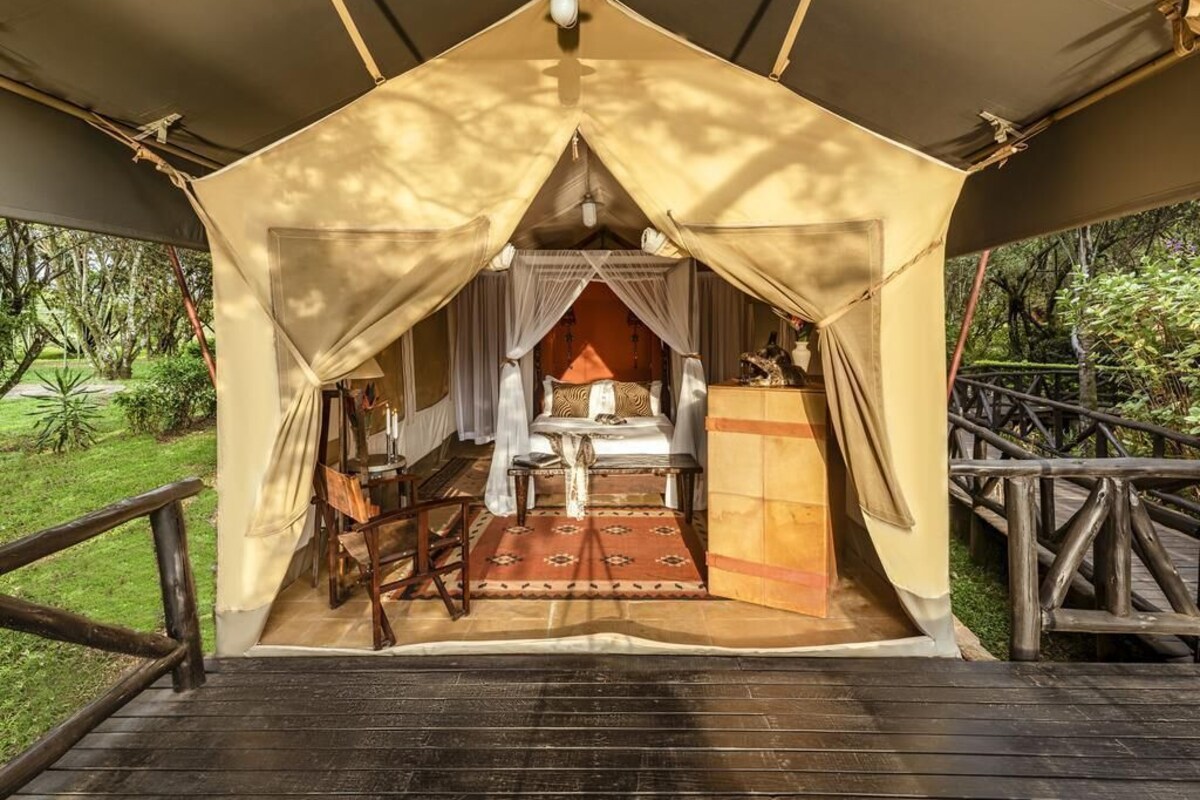 A tent with a bed, a table, and a chair inside.