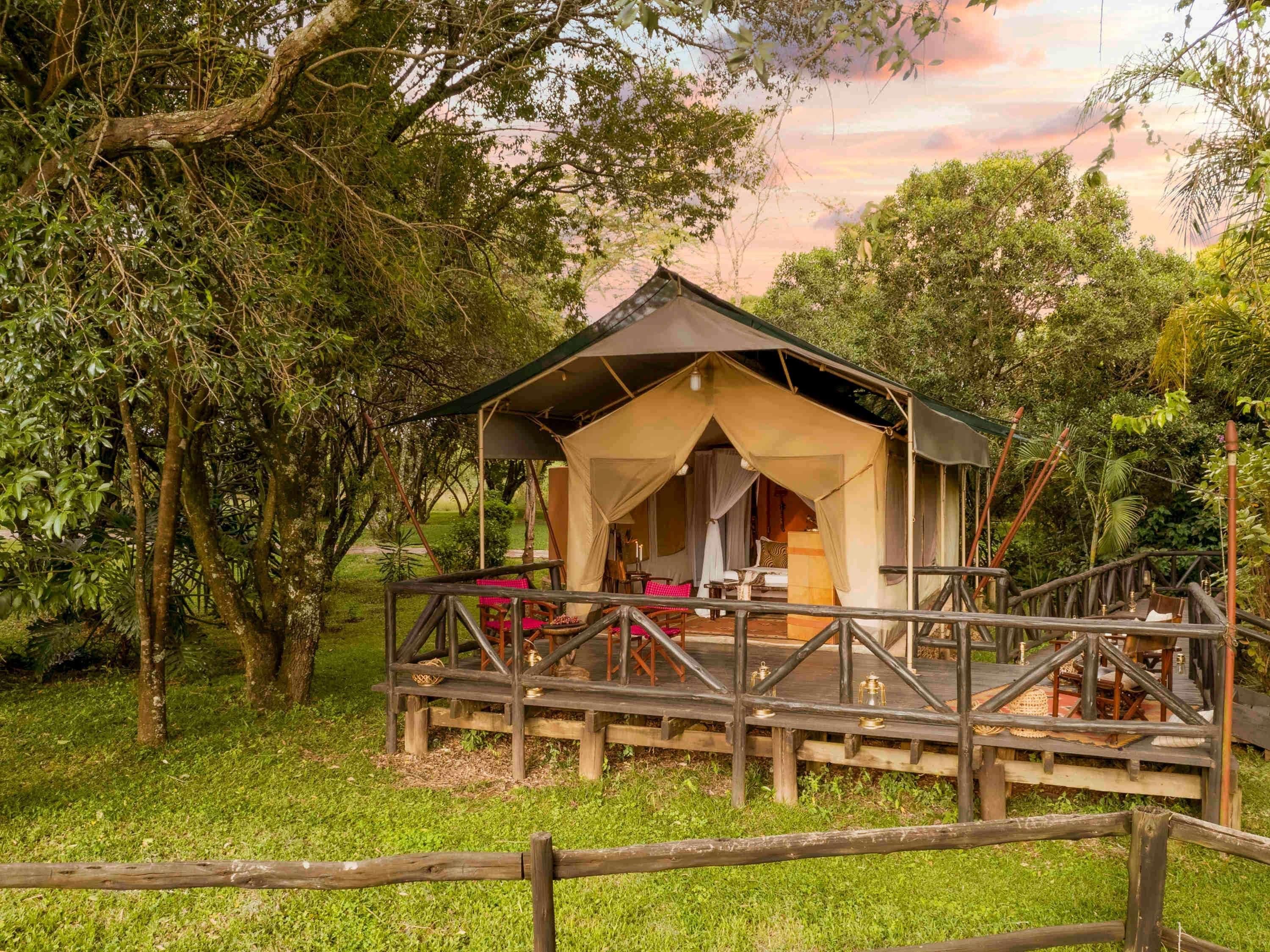 A rustic wooden structure with a covered porch, surrounded by lush greenery.