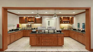 A spacious kitchen with wooden cabinets, a central island, and pendant lighting. - Homewood Suites by Hilton Allentown-Bethlehem Airport (Bethlehem)