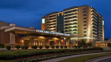 A multi-story hotel with a prominent 'CONCORD CONVENTION CENTER' sign, a landscaped entrance, and a modern architectural design.