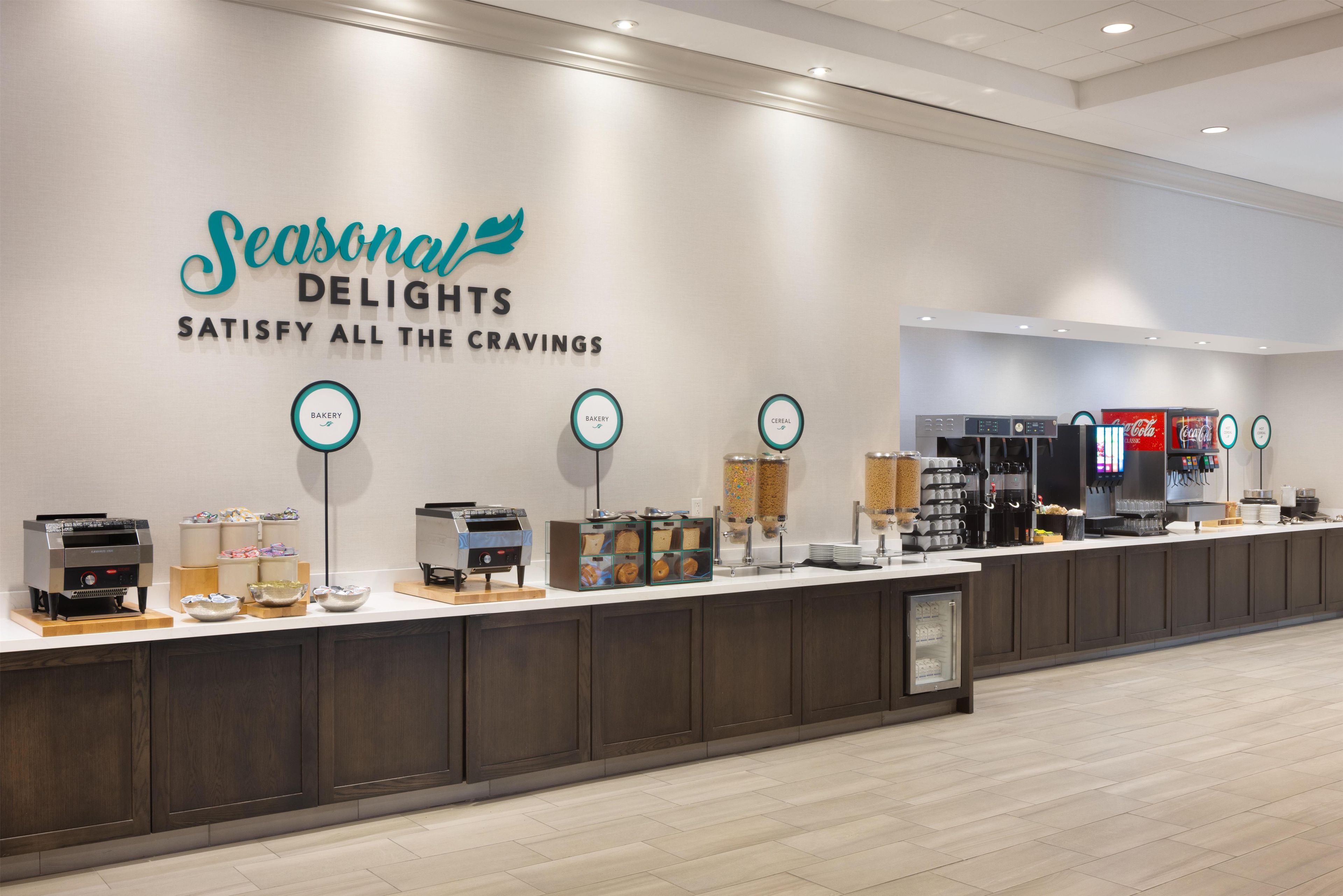 A food service area with a sign reading 'Seasonal Delights Satisfy All the Cravings.'