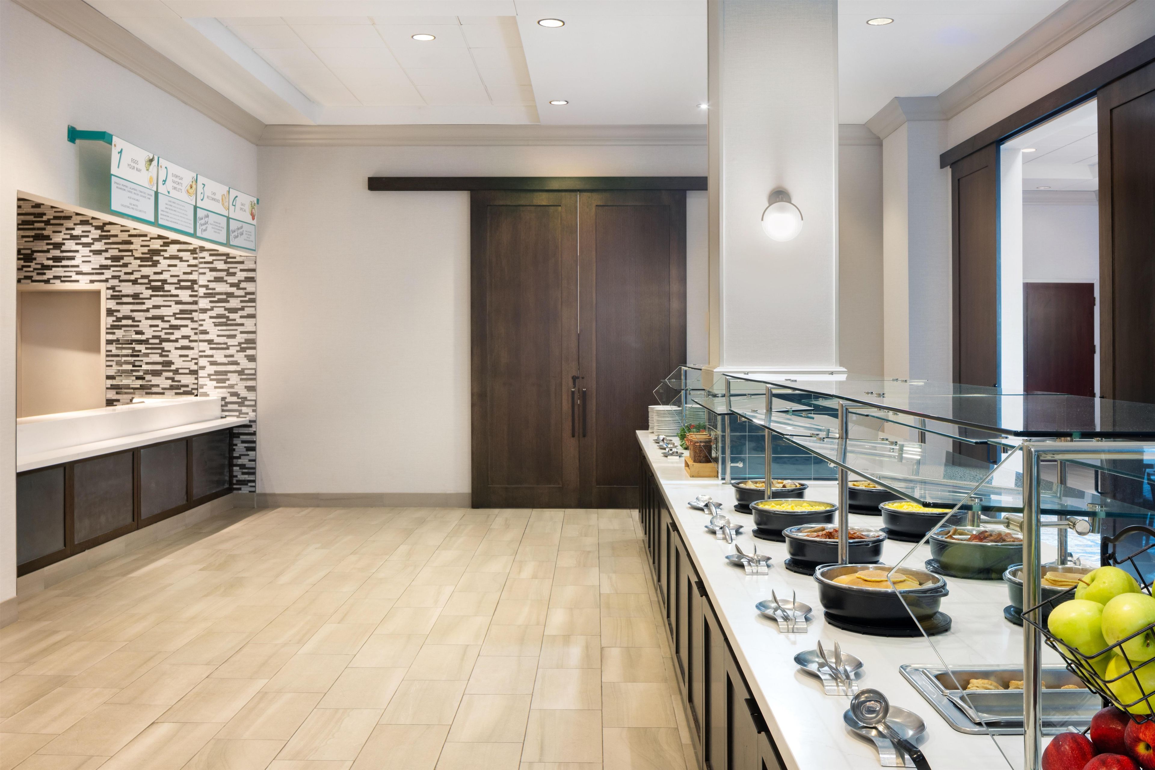 A modern kitchen with a buffet setup, including a variety of food containers and utensils.