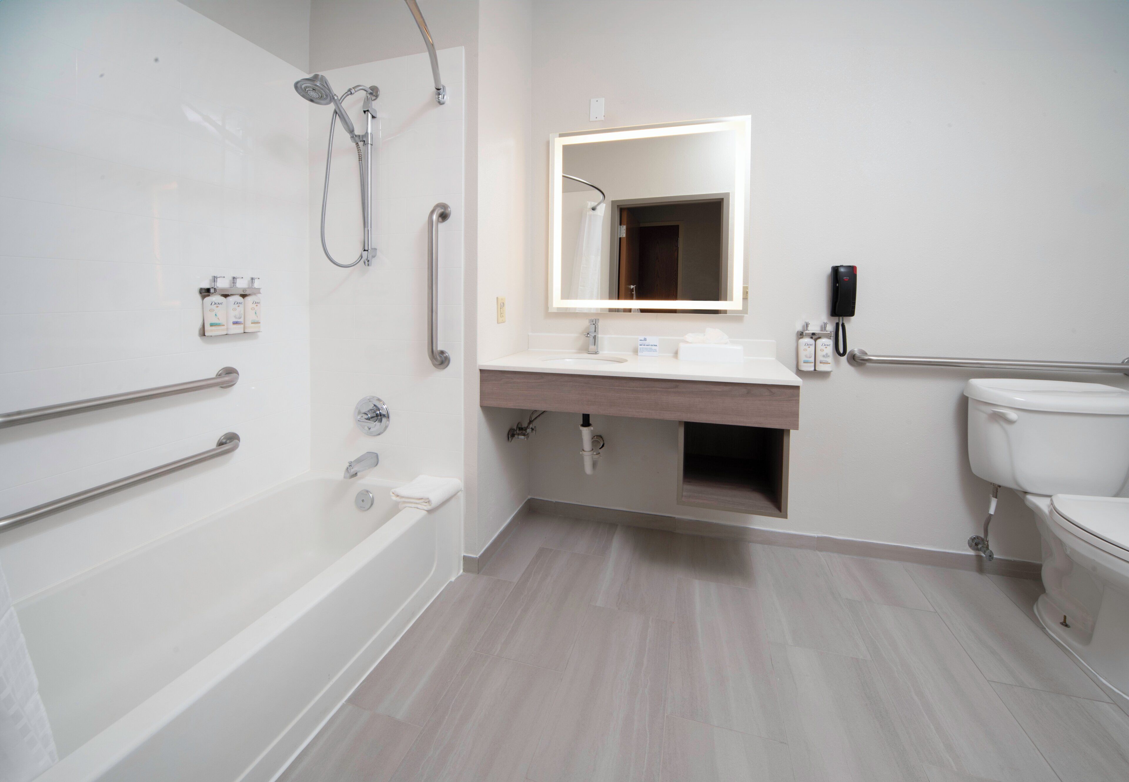 A modern bathroom with a walk-in shower, a bathtub, a vanity with a mirror, and a toilet.