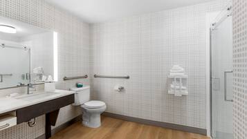 A modern bathroom with a white sink, toilet, and shower.