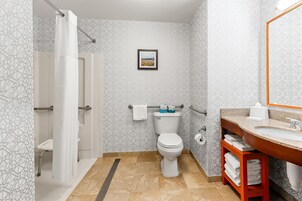 Un baño con ducha, inodoro, lavabo y toallero.