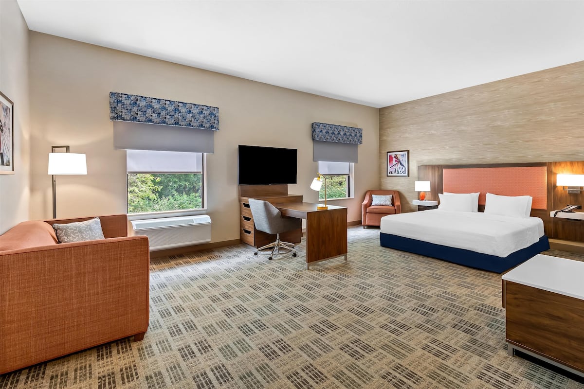 Une chambre d’hôtel équipée d’un lit, d’un bureau, d’une chaise et d’un téléviseur.
