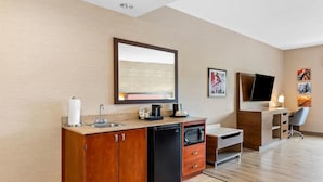 A modern kitchen with a built-in dishwasher, microwave, and a large mirror above the counter.