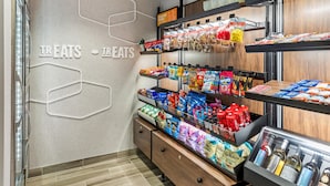 A snack display area with various packaged snacks and a refrigerated section with bottled beverages.