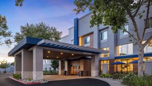 A modern hotel entrance with a covered walkway, clear signage, and a landscaped area. - Hampton Inn & Suites Yuba City (Yuba City)