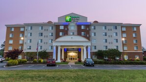 Un hôtel Holiday Inn Express doté d’une façade symétrique, de plusieurs étages et d’une entrée centrale avec une passerelle couverte.