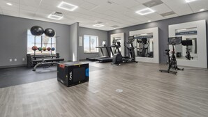 Een sportschool met loopbanden, elliptische trainers en fitnessballen.