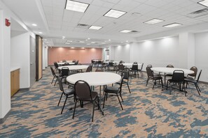 A conference room with multiple tables and chairs, carpeted flooring, and a white ceiling with recessed lighting. - Hampton Inn & Suites Pharr (Pharr)